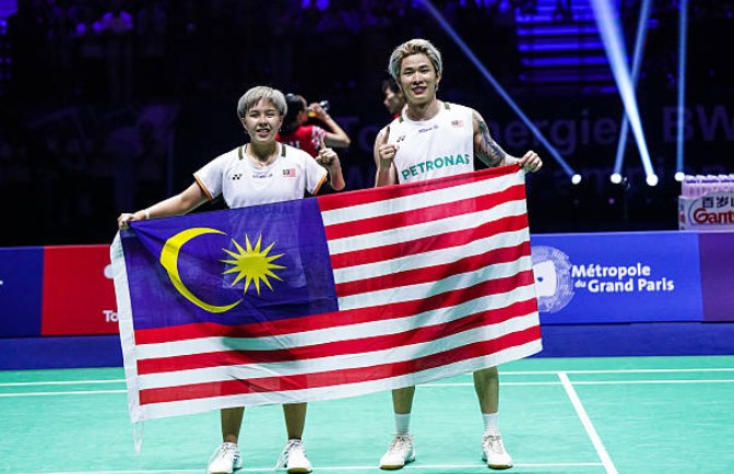 चेन तांग जी और तोह ई वेई ने 2025 बैडमिंटन विश्व चैंपियनशिप में स्वर्ण पदक जीतने के बाद गर्व से मलेशियाई ध्वज पकड़ रखा है। (फोटो: एएफपी)